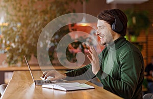 Happy guy with wireless headset having online conference