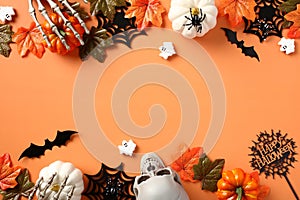 Happy Halloween banner design. Flat lay pumpkins, spiders, webs, skeleton hands, ghosts on orange background