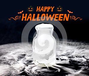 Happy halloween with bat fly in smoke in glass bottle on black b