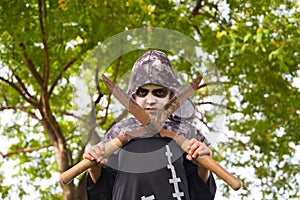 Happy halloween. Boy dressed up for halloween party holding a pair of rusty pruning shears. He is very angry looking at the camera