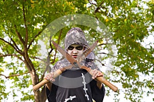 Happy halloween. Boy dressed up for halloween party holding a pair of rusty pruning shears. He is very angry looking at the camera