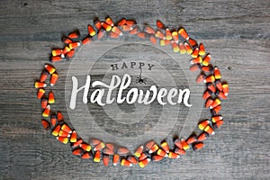 Happy Halloween Calligraphy With Candy Corn Oval Border Over Rustic Wooden Background, Horizontal