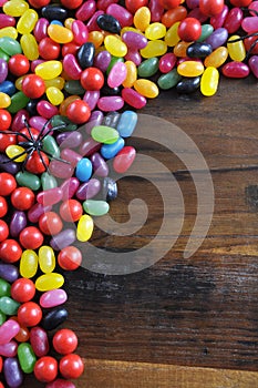 Happy Halloween candy background with spiders on rustic dark wood background