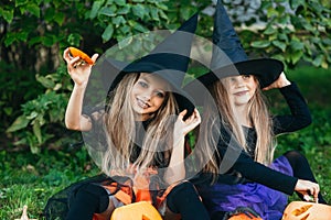 Happy Halloween. Children in suits and with pumpkins having fun outdoor