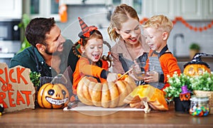 Happy Halloween! family mother father and children cut pumpkin f