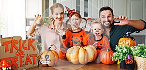 Happy Halloween! family mother father and children cut pumpkin f