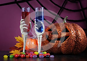 Happy Halloween ghoulish party cocktail drinks with skeleton glasses and pumpkin