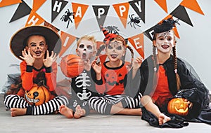 Happy Halloween! a group of children in suits and with pumpkins