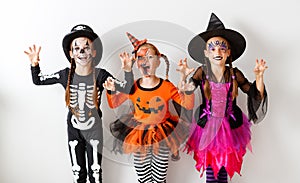 Happy Halloween! a group of children in suits and with pumpkins in blank wall