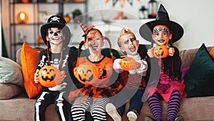 Happy Halloween! group of children in suits and with pumpkins in home