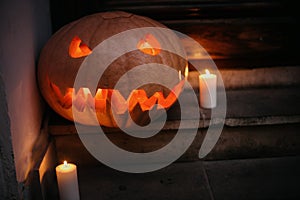 Happy Halloween. Halloween street decor with spooky Jack-o`-lantern. Pumpkin with scary carved glowing face and candle light in