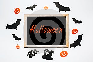 Happy halloween holiday concept. Notepad with text on white and black background with bats, pumpkins and ghosts