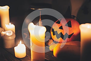 Happy Halloween. Jack o lantern pumpkin with candles, bowl, witch broom and bats, ghosts on background in dark spooky room. fall