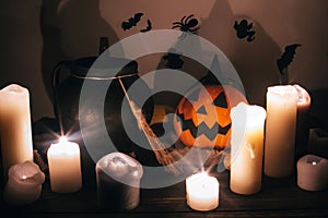 Happy Halloween. Jack o lantern pumpkin with candles, bowl, witch broom and bats, ghosts on background in dark spooky room. fall