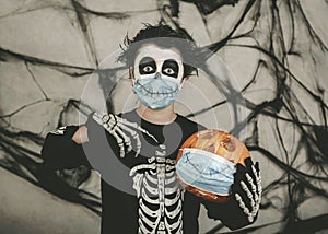 Happy Halloween,kid wearing medical mask in a skeleton costume with halloween pumpkin