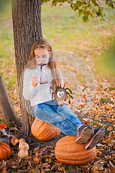 Happy Halloween! Little girl carving pumpkin at Halloween. Dressed up children trick or treating. Kids trick or treat. Toddler kid