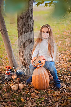 Happy Halloween! Little girl carving pumpkin at Halloween. Dressed up children trick or treating. Kids trick or treat. Toddler kid