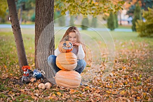 Happy Halloween! Little girl carving pumpkin at Halloween. Dressed up children trick or treating. Kids trick or treat. Toddler kid