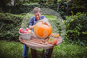 Happy halloween. Man carving big pumpkin Jack O Lanterns for Halloween outside. Close-up