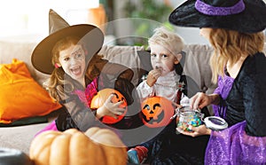 Happy Halloween! mother treats children with candy at home