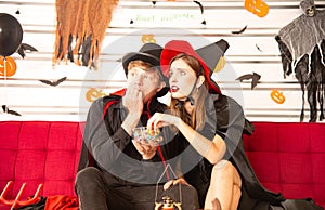 Happy Halloween party concept. Young man and woman wearing as vampires, witch or ghost celebrate the halloween festival