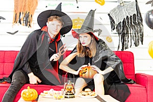 Happy Halloween party concept. Young man and woman wearing as vampires, witch or ghost celebrate the halloween festival