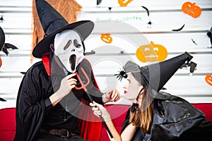 Happy Halloween party concept. Young man and woman wearing as vampires, witch or ghost celebrate the halloween festival