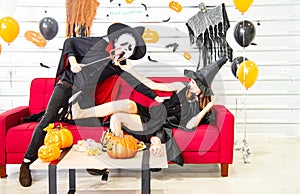 Happy Halloween party concept. Young man and woman wearing as vampires, witch or ghost celebrate the halloween festival