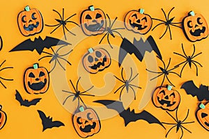 Happy Halloween. Pumpkins jack o lantern, spiders and bats flat lay on orange background. Halloween decorations layout on orange