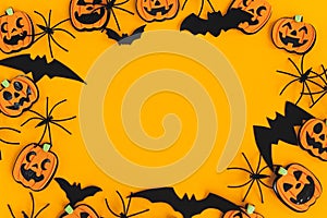 Happy Halloween. Pumpkins jack o lantern, spiders, bats frame on orange background flat lay with space for text. Halloween