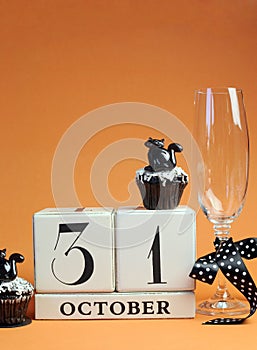 Happy Halloween save the date white block calendar with champagne glass and chocolate muffins - vertical with copy space.
