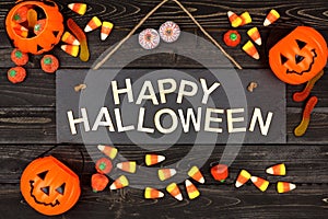 Happy Halloween sign and frame of candy on black wood