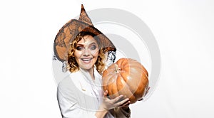 Happy Halloween. Smiling girl in witch hat with pumpkin. Traditional food. Preparation for Halloween holidays. Sexy