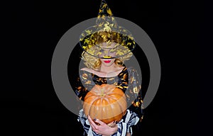 Happy Halloween. Smiling woman in witch hat with pumpkin. Pretty girl in witches costume with jack-o-lantern.