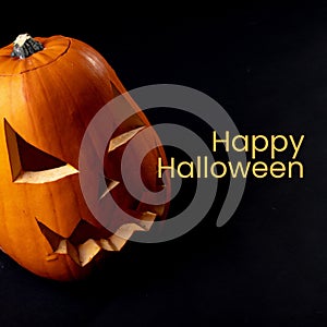 Happy halloween text over carved jack o lantern pumpkin on black background