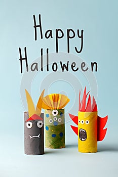 HAPPY HALLOWEEN text, Paper toy ghost, bat, monsters for Halloween party. Easy crafts for kids on blue background, diy creative