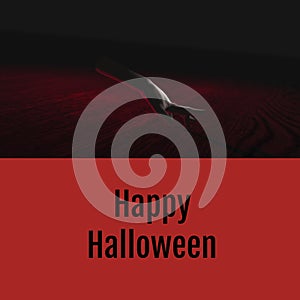 Happy halloween text on red with ghostly severed caucasian hand walking on dark background