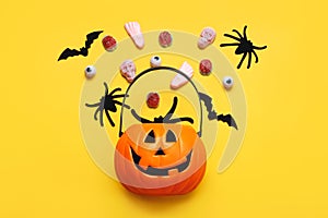 Happy Halloween. Top view of Halloween pumpkin basket full of candies, bats and spiders. Halloween concept background