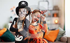 Happy Halloween! two children in suits and with pumpkins in home