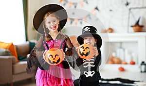 Happy Halloween! two children in suits and with pumpkins in home