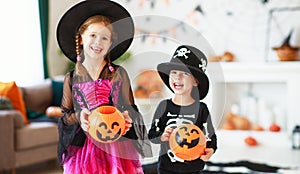 . happy Halloween! two children in suits and with pumpkins in home