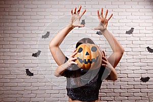 Happy Halloween! Two young cute women with pumpkin head frighten