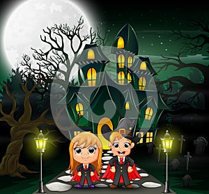 Happy halloween vampire and witch in front of the haunted house with full moon background