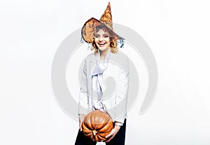 Happy Halloween witch with pumpkin. Smiling Halloween party girl in witch hat with big pumpkin. Happy Halloween Weekends