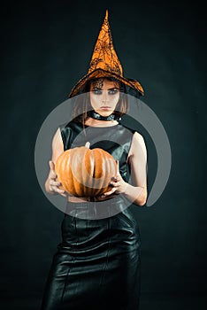 Happy Halloween witch with pumpkin. Witch magic. Sexy girl in Halloween costume. Secrets of magic.