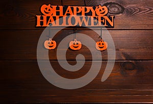 Happy Halloween written on a Happy Halloween written on a signboard with pumpkins on a Wooden Background