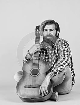 happy handsome bearded guy with unshaven face and stylish hairdo wear casual clothes play guitar, musician