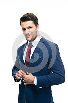 Happy handsome businessman putting on suit jacket