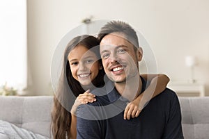 Happy handsome dad and cheerful girl looking at camera