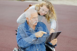 happy handsome father in wheelchair and daughther outdoors photo